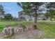 Spacious backyard with a fire pit, mature trees, and a gray two-story home at 36700 Mossberg Ct, Elizabeth, CO 80107