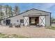 Exterior view of horse barn including chairs, planters, gravel and sliding stall doors at 36700 Mossberg Ct, Elizabeth, CO 80107