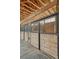 Close-up of horse stalls, featuring wood paneling, metal bars, and concrete flooring at 36700 Mossberg Ct, Elizabeth, CO 80107