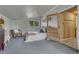 This bedroom features a cozy chair, a queen size bed, and an entrance to a wood paneled bathroom at 36700 Mossberg Ct, Elizabeth, CO 80107