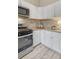 Well-lit kitchen boasts stainless steel appliances, sleek white cabinets, and stone countertops at 36700 Mossberg Ct, Elizabeth, CO 80107