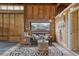 The living room features a leather couch, a coffee table, and a wall of wood paneling and rustic decor at 36700 Mossberg Ct, Elizabeth, CO 80107