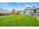View of backyard with large lawn, storage shed, and fenced perimeter at 6568 S Dahlia Cir, Centennial, CO 80121