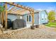 View of the backyard patio with wooden pergola, grill, and stone landscaping at 6568 S Dahlia Cir, Centennial, CO 80121