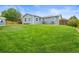 Expansive backyard with lush green lawn, shed, wooden fence, and home exterior at 6568 S Dahlia Cir, Centennial, CO 80121
