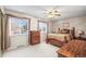 Charming bedroom with a ceiling fan, plush carpet, and natural light from the windows at 6568 S Dahlia Cir, Centennial, CO 80121