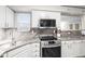 Updated kitchen featuring marble countertops, stainless steel appliances and white cabinets at 6568 S Dahlia Cir, Centennial, CO 80121