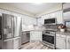 Gorgeous updated kitchen with stainless steel appliances, white cabinets and marble backsplash at 6568 S Dahlia Cir, Centennial, CO 80121