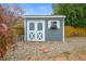 Backyard shed with white double doors and a window box on a gravel base at 6568 S Dahlia Cir, Centennial, CO 80121