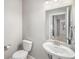 Bright bathroom featuring a toilet and pedestal sink with modern fixtures and neutral color scheme at 11250 Florence St # 29D, Commerce City, CO 80640
