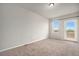 Bright bedroom with neutral carpeting, a window, and a door leading to an outdoor balcony at 11250 Florence St # 29D, Commerce City, CO 80640