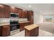 Open concept kitchen with stainless steel appliances, a butcher block island, and access to the living area at 11250 Florence St # 29D, Commerce City, CO 80640