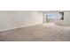 Spacious living room with carpet, natural light and a sliding door that leads to the outdoor balcony at 11250 Florence St # 29D, Commerce City, CO 80640