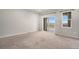 Neutral colored carpeted living room with natural light from sliding glass doors to a balcony at 11250 Florence St # 29D, Commerce City, CO 80640
