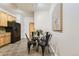 Cozy dining area features a glass table, four black chairs, and an adjacent kitchen with wooden cabinets at 4221 S Blackhawk Cir # 7G, Aurora, CO 80014