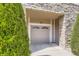 Attached garage door with tan siding, stone accents and mature landscaping at 4221 S Blackhawk Cir # 7G, Aurora, CO 80014
