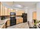 Well-equipped kitchen featuring oak cabinets, black appliances, and tile flooring at 4221 S Blackhawk Cir # 7G, Aurora, CO 80014
