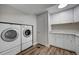 Basement laundry room with washer, dryer, cabinets, and vinyl flooring at 1641 Castlewood Dr, Franktown, CO 80116