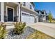 Close-up of the front entrance with a stone accent, lush landscaping and a three car garage at 17341 Red Cosmos Pt, Parker, CO 80134