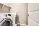 Laundry room featuring modern washer and dryer with a shelf above at 17341 Red Cosmos Pt, Parker, CO 80134