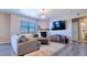 Inviting living room with a comfortable couch, fireplace, large TV, and stylish light fixture at 17341 Red Cosmos Pt, Parker, CO 80134