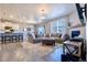 Open living room with modern fireplace, wood floors, large sectional, and lots of natural light at 17341 Red Cosmos Pt, Parker, CO 80134