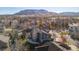 Aerial view of home in a neighborhood with mountain backdrop and mature trees at 6389 Umber Cir, Arvada, CO 80403