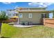 Green house backyard with patio, fence, and lawn under a blue sky at 18372 E 100Th Pl, Commerce City, CO 80022