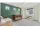 Bedroom featuring a wooden crib, accent wall, ample natural light, and cozy carpeting at 18372 E 100Th Pl, Commerce City, CO 80022