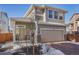 Two-story home with gray siding, brick accents, and a two-car garage at 18372 E 100Th Pl, Commerce City, CO 80022