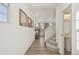 Hallway with hardwood floors, white walls, decorative mirrors, and access to a half bath at 18372 E 100Th Pl, Commerce City, CO 80022