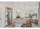 Modern kitchen and dining area with a granite island, stainless steel refrigerator, and hardwood floors at 18372 E 100Th Pl, Commerce City, CO 80022