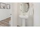 Elegant powder room with a pedestal sink, modern fixtures, and stylish mirror at 18372 E 100Th Pl, Commerce City, CO 80022