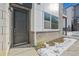 Modern home exterior with a gray door and stone accents at 461 Interlocken Blvd # 102, Broomfield, CO 80021