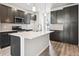 Modern kitchen with island, stainless steel appliances, and dark cabinetry at 461 Interlocken Blvd # 102, Broomfield, CO 80021