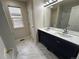 Bright bathroom with double sinks, white marble floors and a large mirror at 3223 Castle Peak Ave, Superior, CO 80027