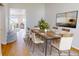 Dining room with a modern wood table, six chairs, and view to staircase and entry at 3223 Castle Peak Ave, Superior, CO 80027