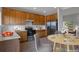 Cozy kitchen area with wooden cabinetry, modern appliances, and a round breakfast table set for dinner at 3223 Castle Peak Ave, Superior, CO 80027