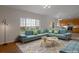 Open living room with a modern sofa, large windows, and views of the yard at 3223 Castle Peak Ave, Superior, CO 80027