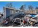 Exterior view of a blue house with various items scattered in the yard at 47 Osceola St, Denver, CO 80219