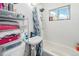 Bright bathroom with a tub and shower, tiled walls, and storage shelves at 47 Osceola St, Denver, CO 80219