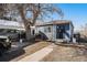 Cozy blue home with a well-maintained front yard and driveway parking at 47 Osceola St, Denver, CO 80219