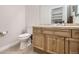 Bathroom with double sinks, oak vanity, tile floors, toilet, walk-in shower, and built-in shelving at 4346 S Quail St, Littleton, CO 80127