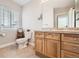 Bright bathroom featuring a vanity with storage and a toilet, complemented by neutral tiling at 4346 S Quail St, Littleton, CO 80127