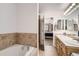Well-lit bathroom featuring double sinks, light wood cabinetry, and tile backsplash at 4346 S Quail St, Littleton, CO 80127