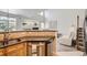 Bright kitchen with granite countertops open to living room with fireplace, tall windows, and staircase at 4346 S Quail St, Littleton, CO 80127