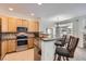 Open kitchen featuring stainless steel appliances, granite countertops, and breakfast bar with pendant lighting at 4346 S Quail St, Littleton, CO 80127