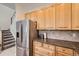 Kitchen featuring stainless steel appliances, oak cabinets, granite countertops, and stairs leading to the upper level at 4346 S Quail St, Littleton, CO 80127