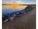 A scenic lake with a rocky shoreline, trail, and a colorful sunset at 4346 S Quail St, Littleton, CO 80127