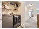 Convenient laundry room equipped with modern washer and dryer units and shelving at 4346 S Quail St, Littleton, CO 80127